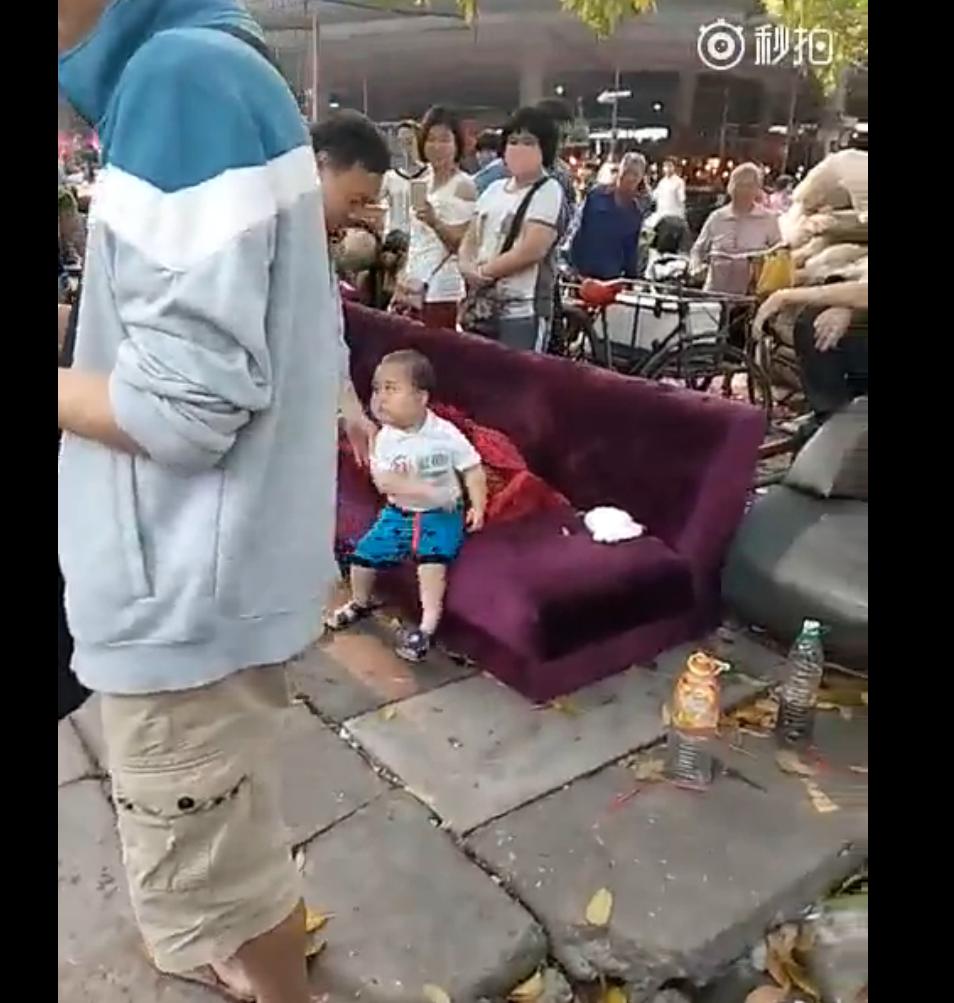 视频中可以看出，有一个穿着城管制服的男子将小朋友扶到沙发上坐下，但是小男孩还是很“气愤”，并不“买账”