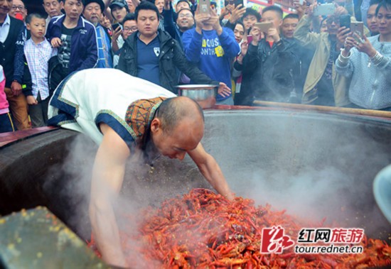 8日下午，张家界火宫殿溪步老街店前出炉了一锅用手炒出的麻辣龙虾，引起众多游客围观。